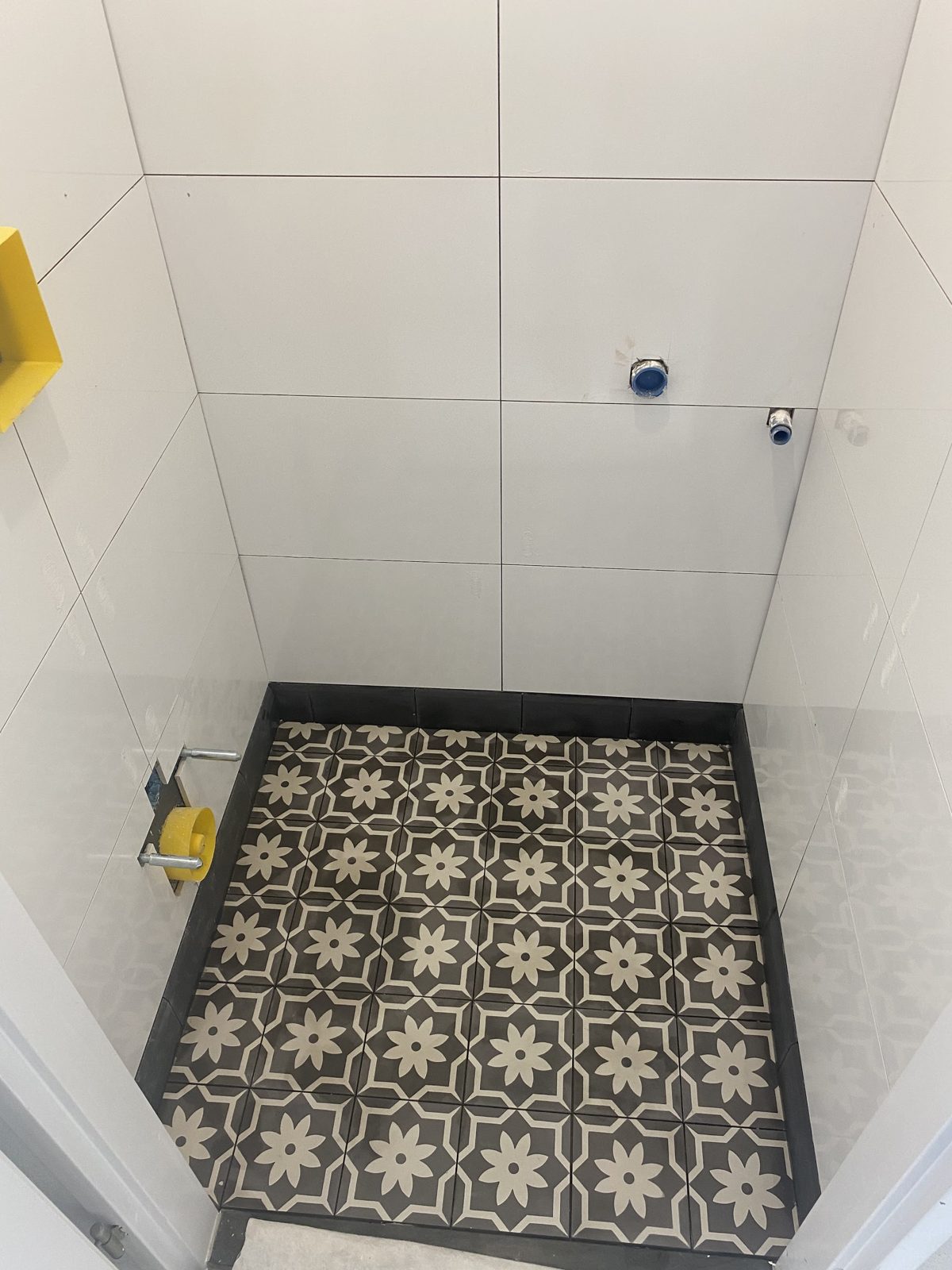 Douchevloer met zwart-wit patroontegels in cementlook, van bovenaf gezien